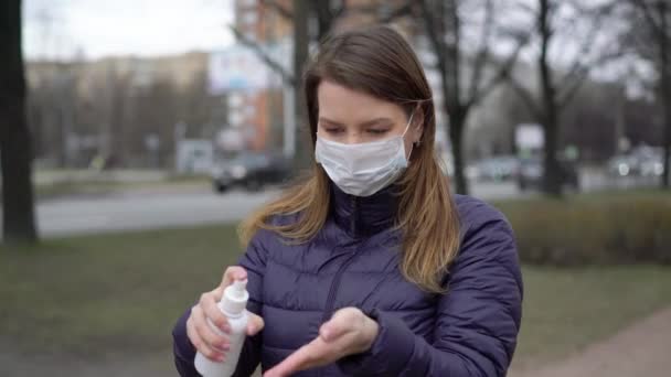 Kvinna i ansiktet skyddsmask i en stad med hand saneringsmedel covid-19 coronavirus — Stockvideo