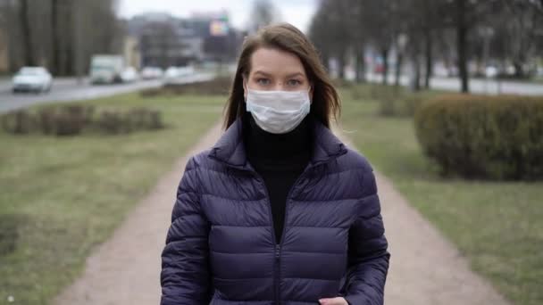 Uma mulher com máscara protectora numa cidade. Epidemia pandémica covid-19 coronavírus — Vídeo de Stock