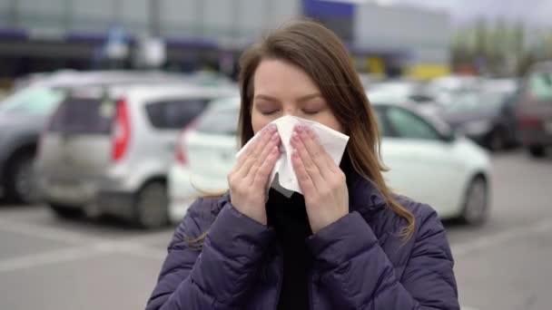 Mujer sonándose la nariz en una toalla de papel en una calle. Covid-19 epidémico coronavirus — Vídeo de stock