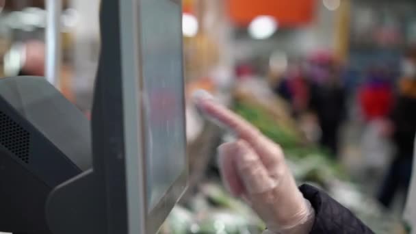 Vrouw in handschoenen gebruikt schaal in de supermarkt supermarkt covid-19 coronavirus — Stockvideo