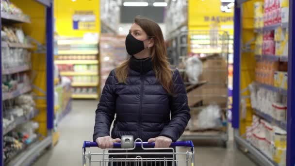 Femme en masque de protection du visage dans un chariot de magasin de supermarché à covid-19 coronavirus — Video