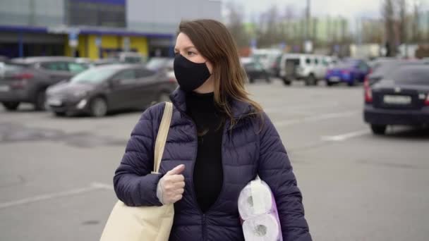 Mujer en la cara máscara protectora con productos después del supermercado. covid-19 coronavirus — Vídeo de stock