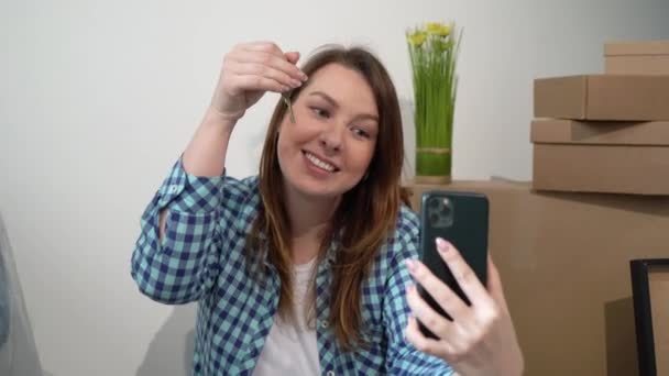 Jeune femme prenant selfie sur téléphone portable. Déménagement maison appartement neuf, boîtes — Video