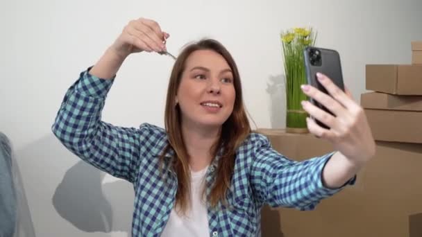 Mujer joven tomando selfie en el teléfono móvil. Mover nuevo apartamento casa, cajas — Vídeo de stock