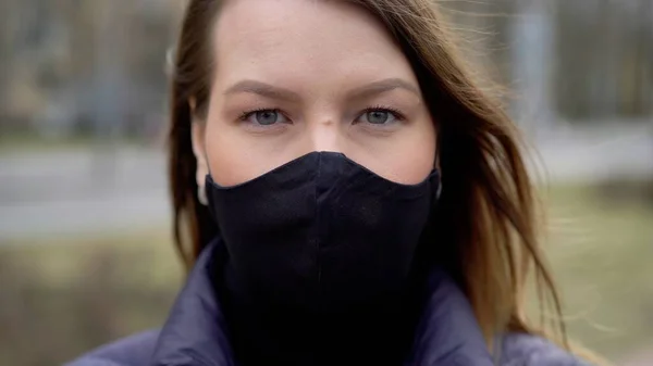 Şehirde koruyucu maskeli bir kadın. Salgın salgın covid-19 coronavirüs