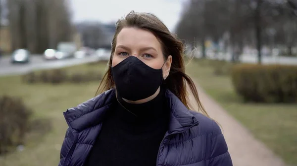 Şehirde koruyucu maskeli bir kadın. Salgın salgın covid-19 coronavirüs