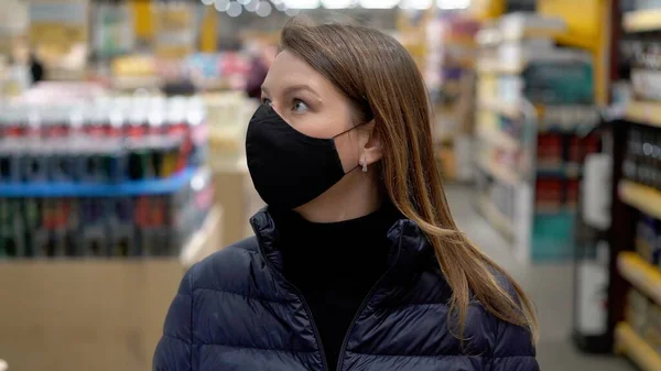 Covid-19 Coronavirus 'taki süpermarket arabasında koruyucu maskeli bir kadın.