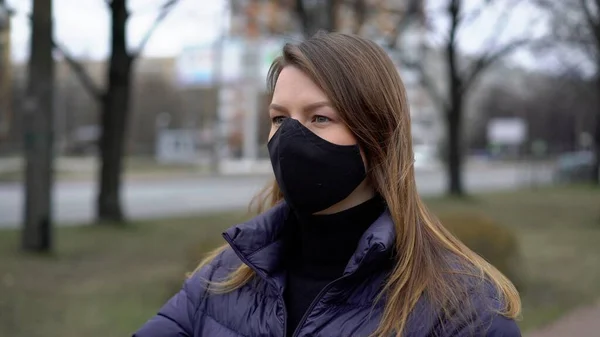 Şehirde koruyucu maskeli bir kadın. Salgın salgın covid-19 coronavirüs