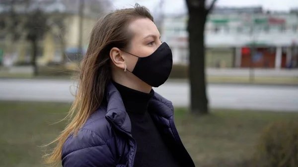 Şehirde koruyucu maskeli bir kadın. Salgın salgın covid-19 coronavirüs