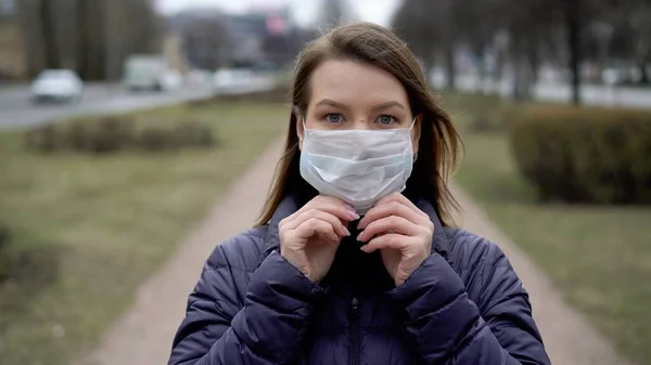 Şehirde koruyucu maskeli bir kadın. Salgın salgın covid-19 coronavirüs