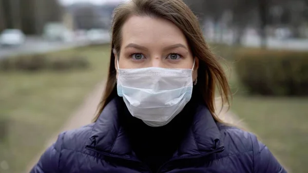 Şehirde koruyucu maskeli bir kadın. Salgın salgın covid-19 coronavirüs