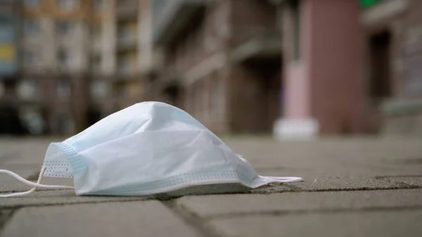 Koruyucu tıbbi maske şehirde yere düştü. Covid-19 Coronavirüs