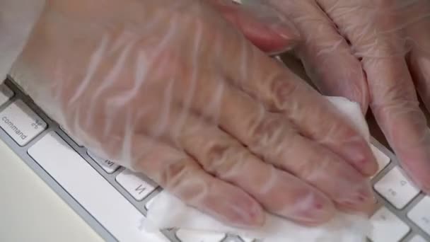 Žena v ochranných rukavicích čištění počítačové klávesnice mokré tkaniny, dezinfekce — Stock video