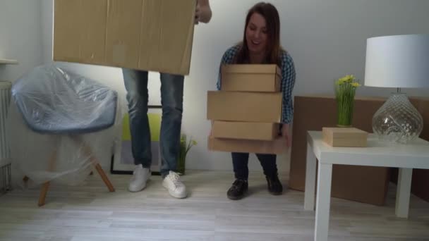 A mudar-se para uma nova casa. Família carrega uma caixa de papelão, proprietário do apartamento — Vídeo de Stock