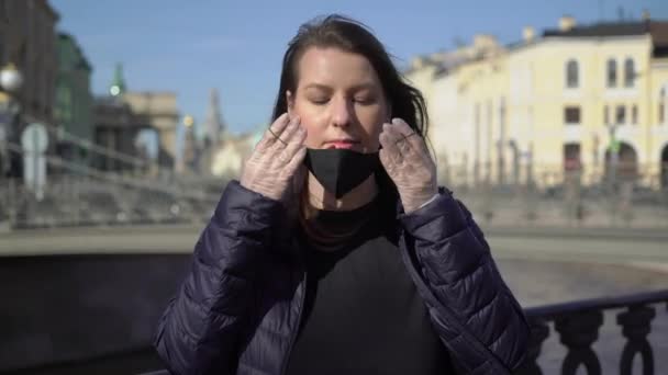 Una mujer se puso una máscara protectora en una ciudad. Covid-19 epidémico coronavirus — Vídeo de stock