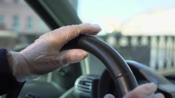 Młoda kobieta prowadzi samochód w rękawiczkach ochronnych. Pandemia koronawiru covid-19. — Wideo stockowe