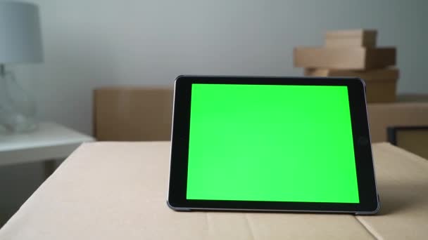 Tablet dengan layar hijau. Pindah atau relokasi ke apartemen atau kantor baru — Stok Video