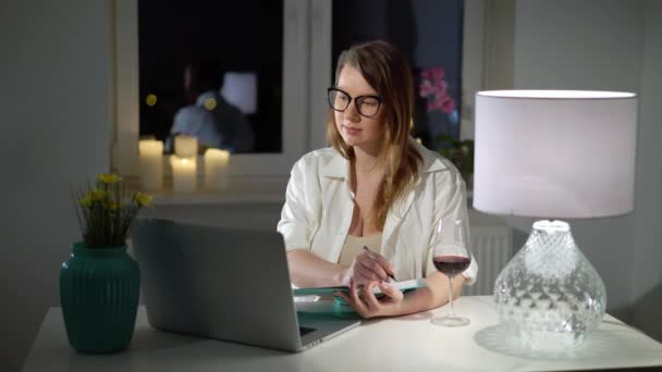Young woman working at computer laptop or study home office evening with wine — Stock Video