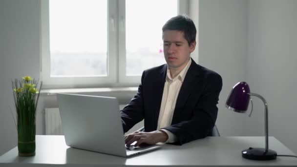 Jeune homme travaillant sur un ordinateur portable au bureau. Travail d'homme d'affaires ou de gestionnaire — Video