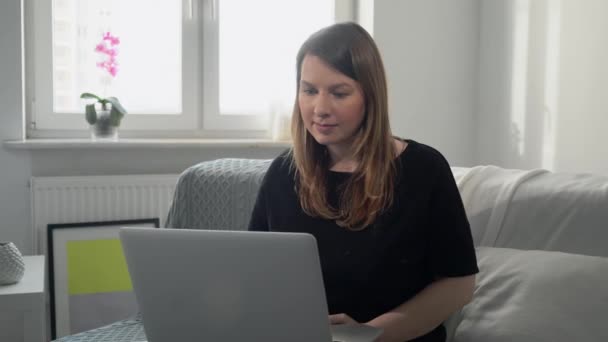 Wanita muda bekerja jauh di rumah dengan laptop komputer. Covid-19 coronavirus — Stok Video