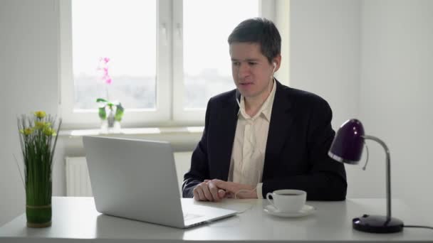 Jongeman werkt op laptop computer in kantoor. Videocall online bijeenkomst — Stockvideo