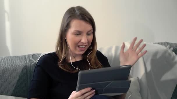 Vrouw met tablet voor videocall of videoconferentie thuis, op afstand werken — Stockvideo