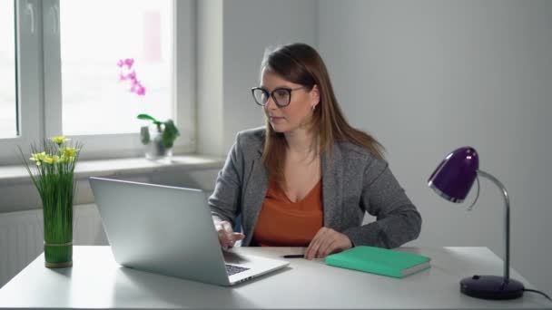 Mujer joven que trabaja en la computadora portátil en la oficina. Trabajo de mujer de negocios o gerente — Vídeos de Stock