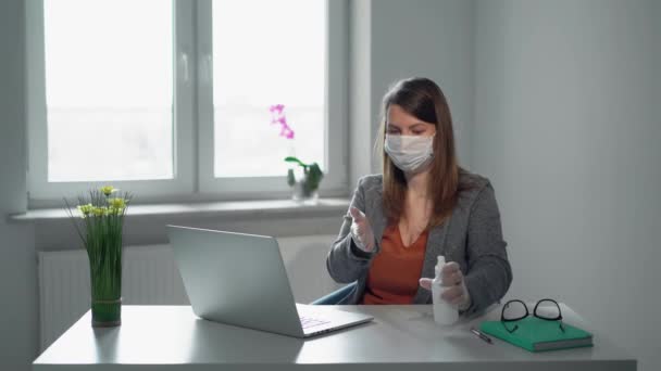Mujer joven que trabaja en el ordenador portátil en la máscara de oficina durante la epidemia covid-19 — Vídeo de stock