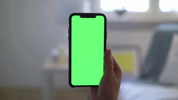 Smartphone se zeleným displejem chromakey, žena drží v ruce a pomocí — Stock video