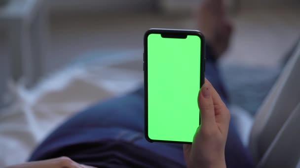 Smartfon z zielonym wyświetlaczem chromakey, kobieta trzyma się za rękę i za pomocą — Wideo stockowe