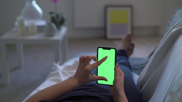 Смартфон с зеленым дисплеем хромаки, женщина держит в руке и с помощью — стоковое видео