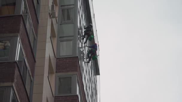 SAINT-PETERSBURG, RÚSSIA - 27 de abril de 2020: Escaladores, limpadores de janelas, lavam vidro de casas residenciais — Vídeo de Stock
