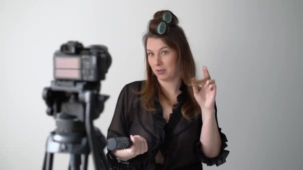 Молодая женщина влиятельный блоггер снимает видео на студию камеры, создавая видео блог — стоковое видео