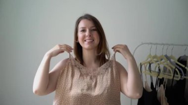 Genç bir kadın elbise seçiyor ve ne giyeceğini arıyor. Depo ya da gardırop