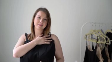 Genç bir kadın elbise seçiyor ve ne giyeceğini arıyor. Depo ya da gardırop