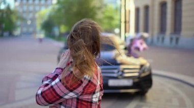 Balon yıldızlı genç bir kadın, arkasında bir araba. Otomatik hediye ya da doğum gününde hediye