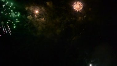 Gecenin karanlığını renkli ışıkla dolduran ve patlayan renkli havai fişekler.
