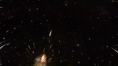 Gecenin karanlığını renkli ışıkla dolduran ve patlayan renkli havai fişekler.