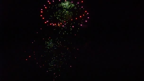 Fuochi d'artificio colorati che esplodono e riempiono il buio del cielo notturno di luce colorata — Video Stock