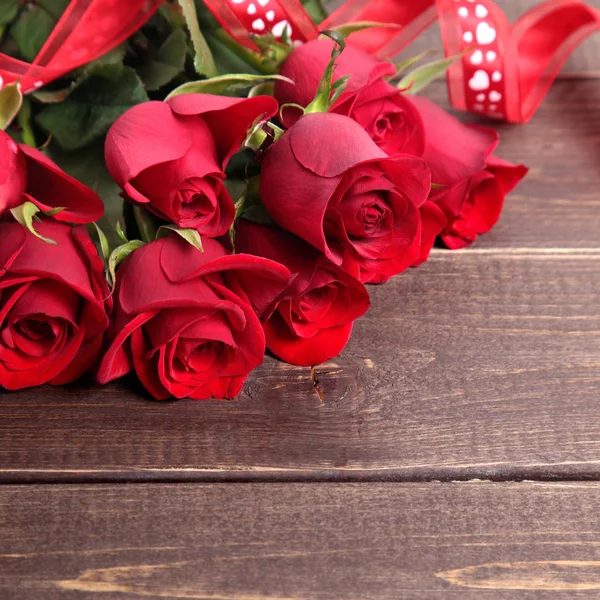 Fond Saint Valentin de roses rouges et ruban sur bois. Espace pour Image En Vente