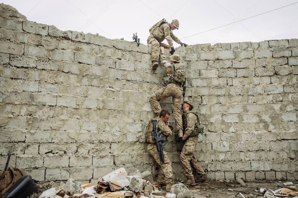 Group of rangers team climbing from a wall