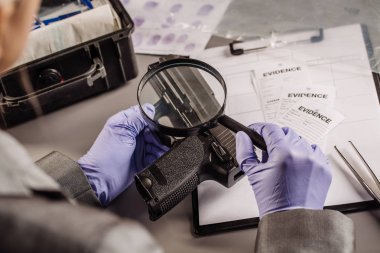 Detective through a magnifying glass looking at a evidence clipart