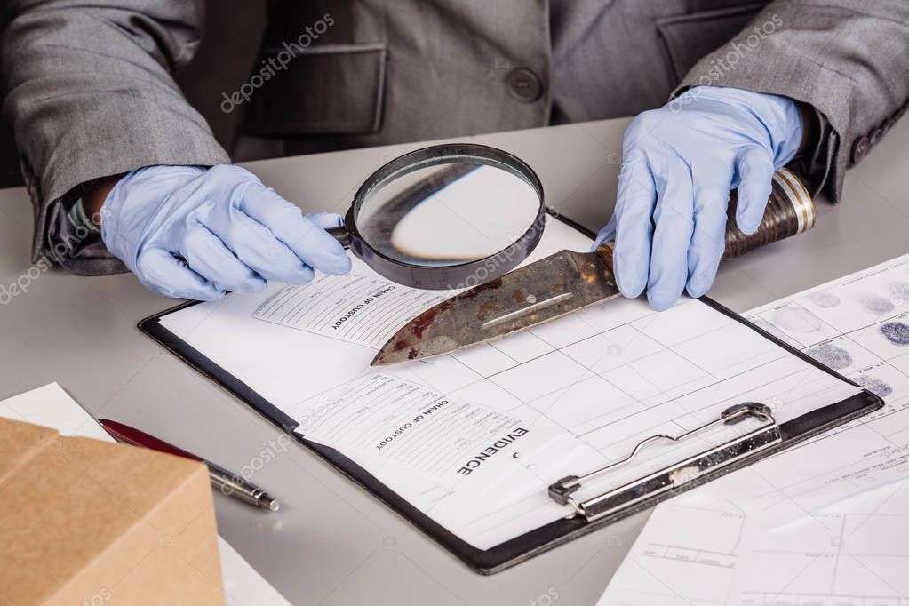Detective through a magnifying glass looking at a evidence 