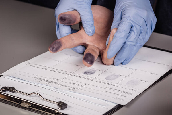 police takes fingerprints of a criminal 