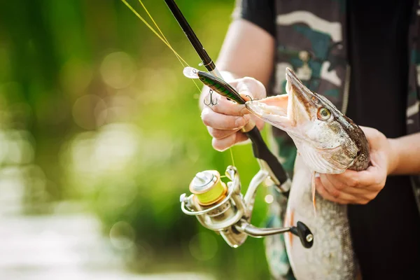 Man håller en fisk på floden — Stockfoto