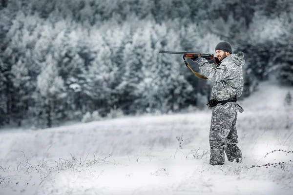 男性猎人在伪装 武装与步枪 站在一个白雪皑皑的冬季森林 — 图库照片