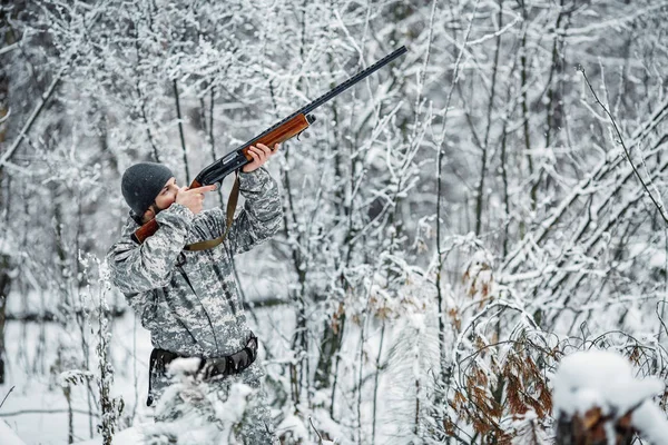 男性猎人在伪装 武装与步枪 站在一个白雪皑皑的冬季森林 — 图库照片