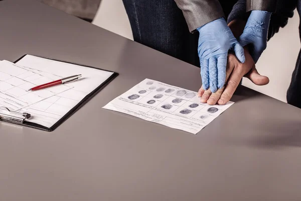 Полиция снимает отпечатки пальцев преступника — стоковое фото