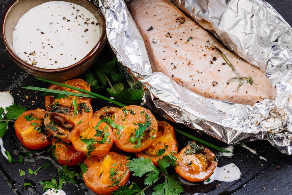 pescado al horno en papel de aluminio sobre la mesa 2023