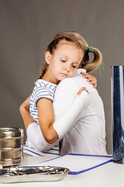 Pequena menina abraçando mulher médico . — Fotografia de Stock